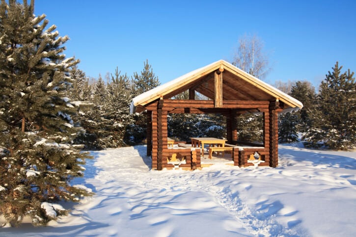 A log-cabin style gazebo is perfect on snowy days. This one has the feel of a high-end ski resort.