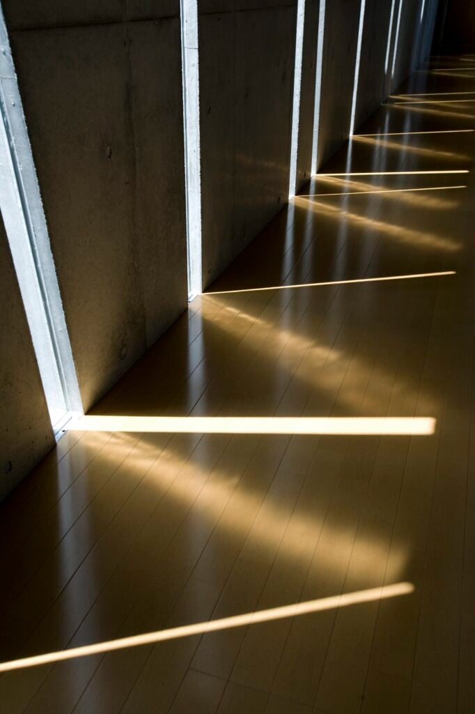 Close view of the natural hardwood flooring highlights the interplay of light from different angles. The sharp lines and soft glows work together to illuminate the home.