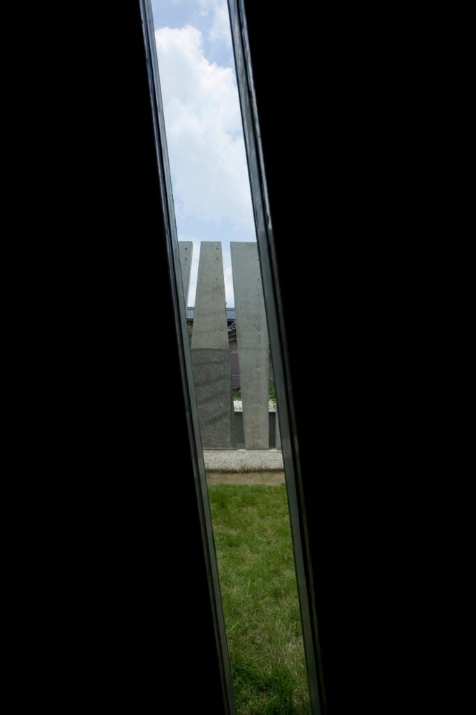 Looking through one of the diagonal slits, we see the lawn and exterior privacy wall.