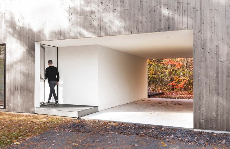 Taking a step away from the house, we get a full sense of how the entryway shares an opening with the garage. The open ended garage is consistent with the home's interior design.