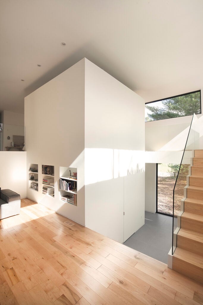 This angle reveals the large "block" which is the central unit which this house was designed around. The staircase wraps up and around it, and into the private bedroom suite. However, it does not extend to the ceiling and there is an opening to the bedroom on the other side, giving this home its open atmosphere.