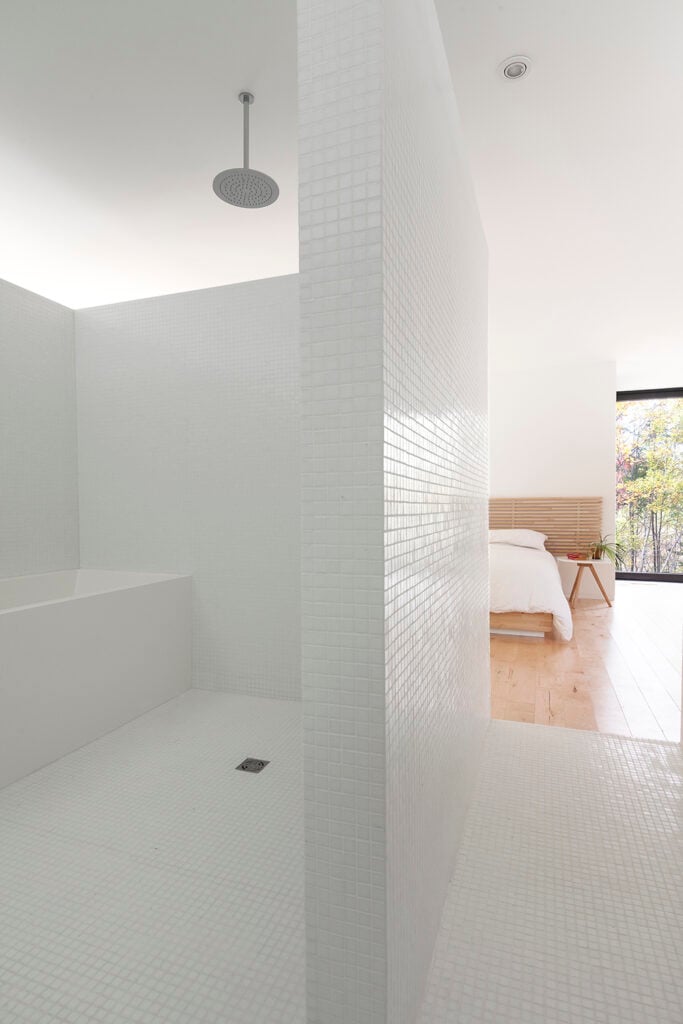 Notice that the bathroom does not have a door, so it was important to design the walls so that one could still have privacy in the bathroom. Small white square tiles cover the entire floor and walls in this space.
