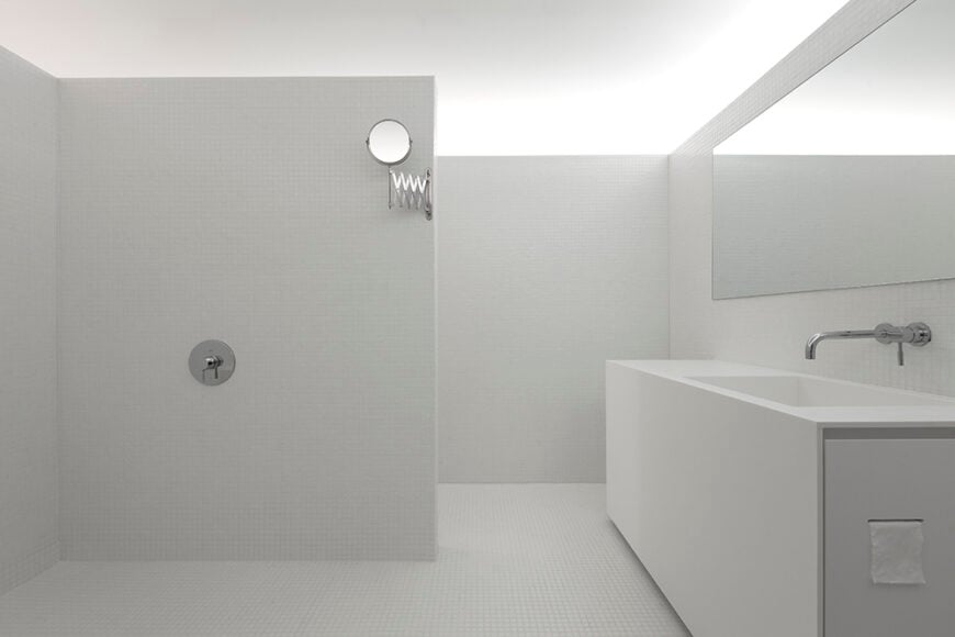 As we enter the full bathroom space, it is much larger than one might expect. This bathroom features a large sink, with an open shower area.
