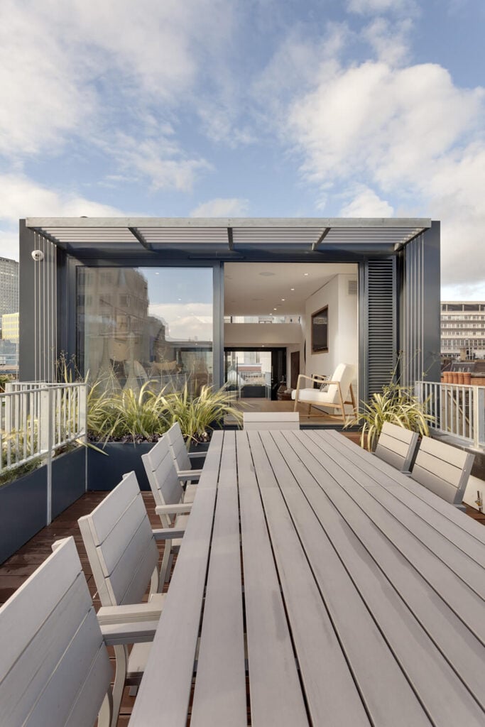 In the light of day, we can see hints of the expansive views available to residents of this home, whether inside behind large windows or outdoors on the rooftop terrace.
