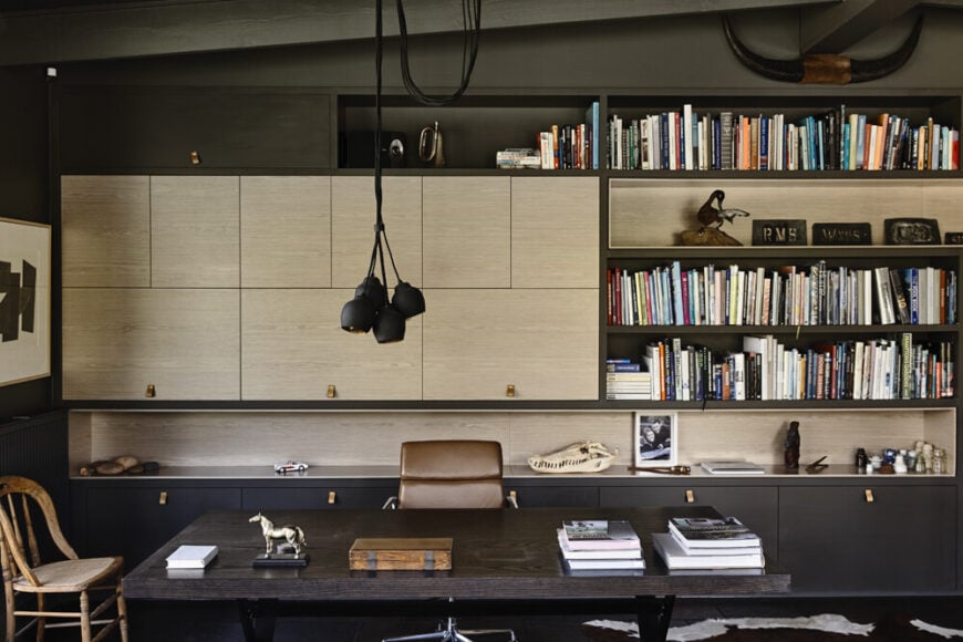 A home office was an important part of the design, a space rife with sleek cabinetry and shelving, centered on a large dark wood desk. The appearance of light toned wood offers a slight break from the prevailing style.