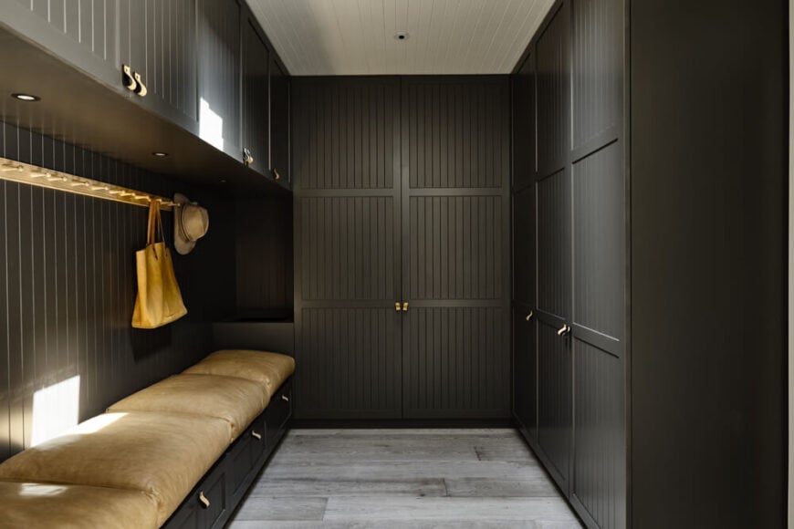 The home features a large storage room with thick cushioned benches and sleek cabinetry matching that seen in the kitchen.