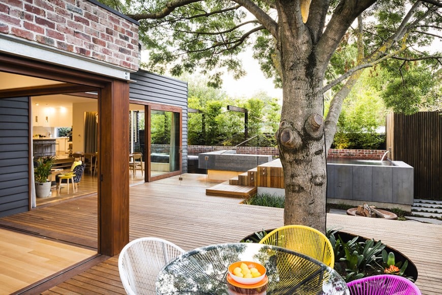 This deck offers a cozy pool and jacuzzi along with a small dining table set near the matured tree providing shade.