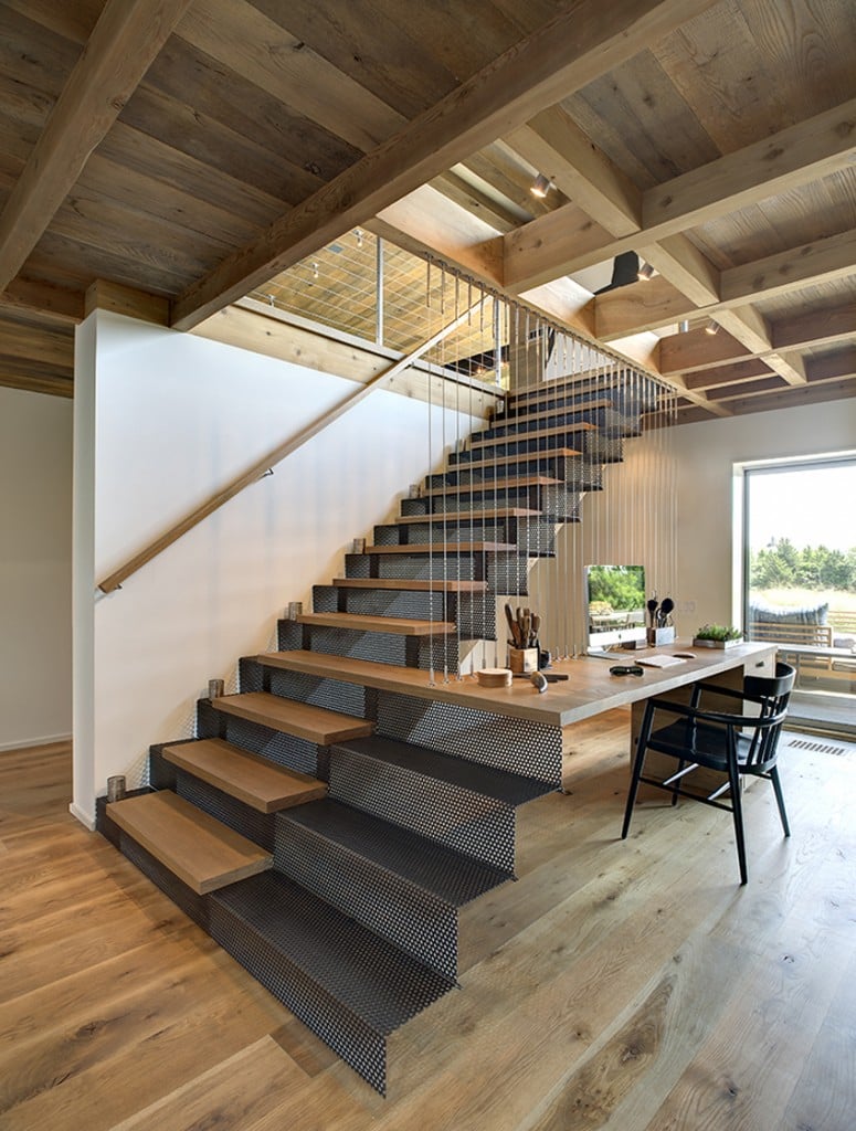 The cozy home office showcases a perforated staircase that extends to the office desk framed with thin metal rods. 