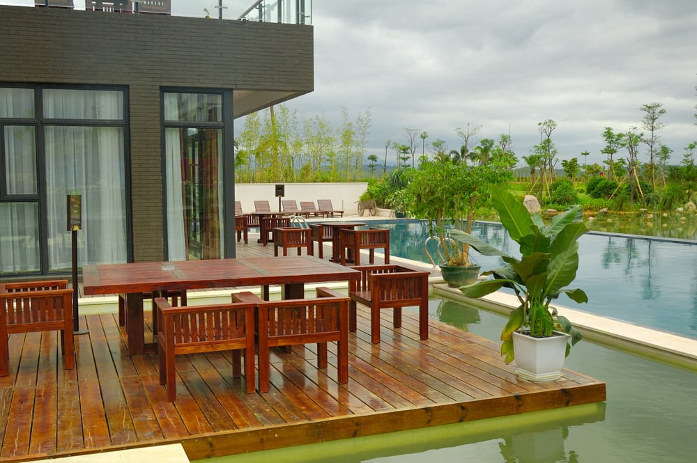 This pool-side deck looks glamorous, offering many dining table sets for family and friends.