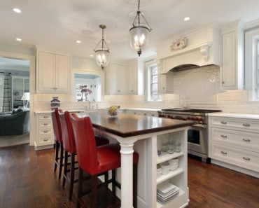 Traditional white kitchen with island and red stools