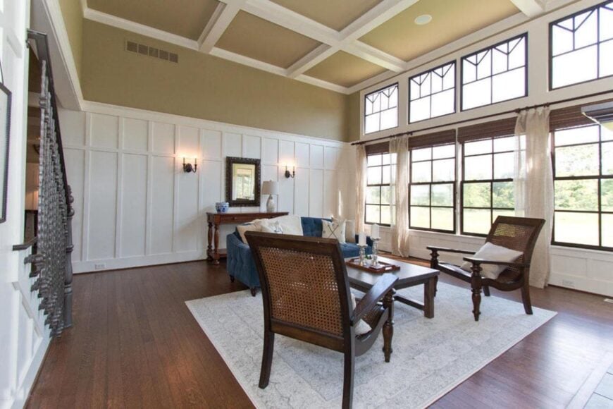 Spacious formal living room featuring hardwood flooring and high coffered ceiling.