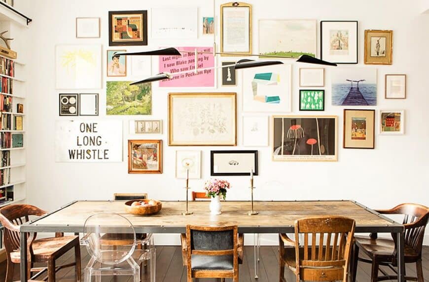 Charming dining room designed with a gallery art wall and unique pendant lights that hung over the dining set.