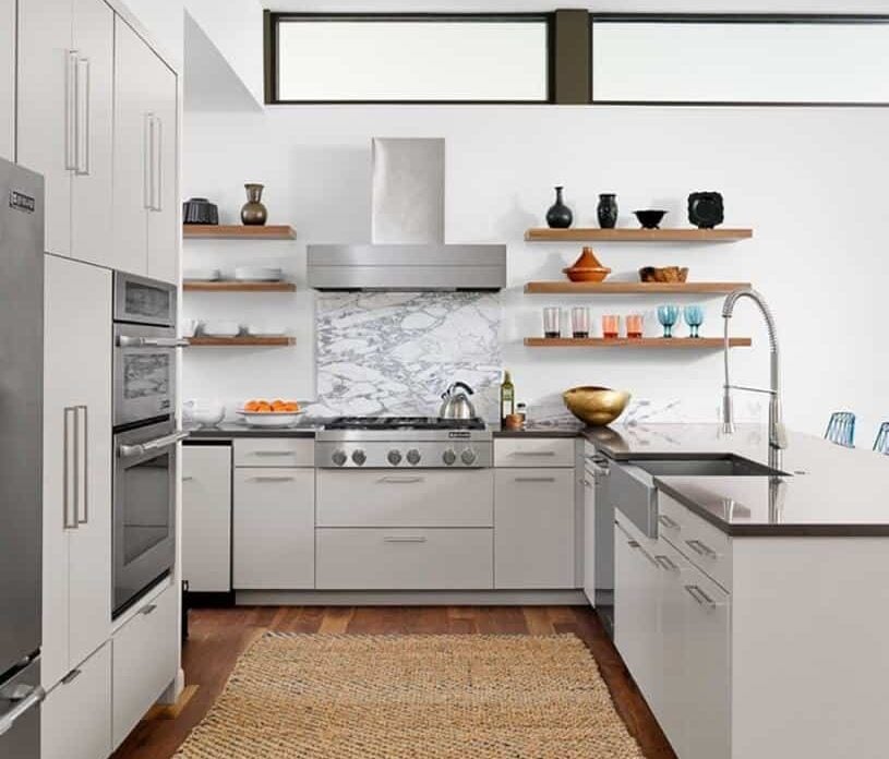 Classy kitchen with a hardwood flooring topped by a rug. The smooth white counters look perfect together with the countertops.