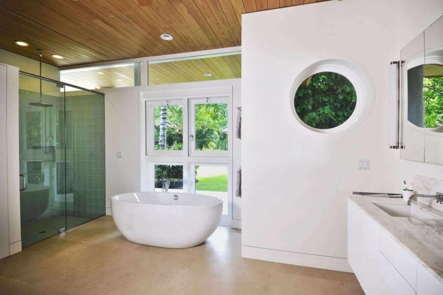 This master bathroom offers a walk-in shower, a freestanding tub and a floating vanity with marble countertop.