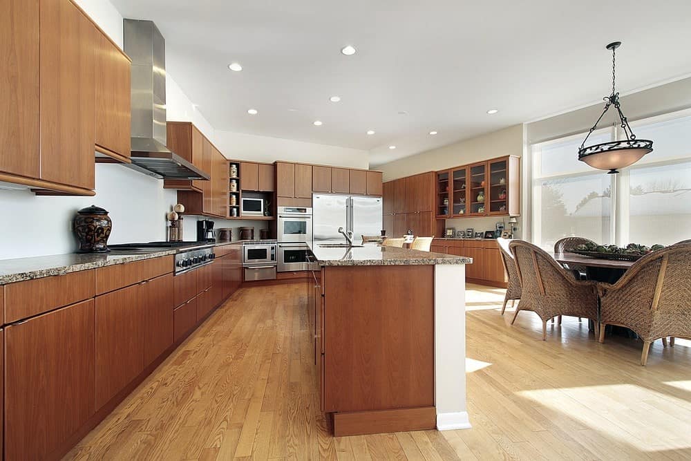 The white ceiling is peppered with recessed lights that cast down bright white lights that brightens the light hardwood flooring together with the natural lights coming in from the large glass windows. This is then balanced with a darker shade of wooden tone of the cabinetry.