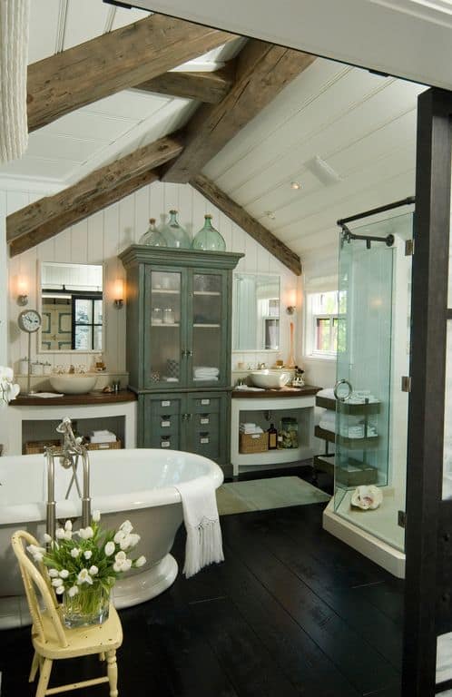 Master bathroom featuring dark hardwood flooring, a vaulted ceiling with rustic beams and white walls, along with a freestanding tub and a walk-in shower room.