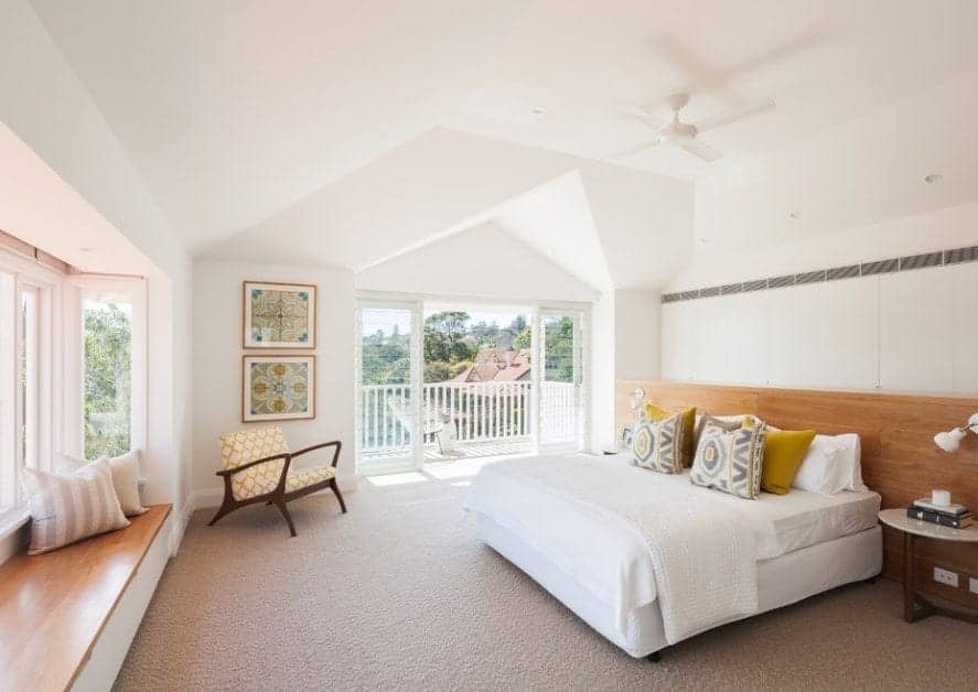 Large Scandinavian-Style primary bedroom featuring a stylish ceiling and classy carpet flooring along with private balcony space.