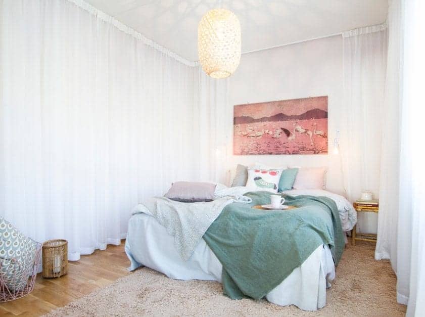 Small Scandinavian-Style primary bedroom featuring lovely white window curtains and a charming pendant lighting.