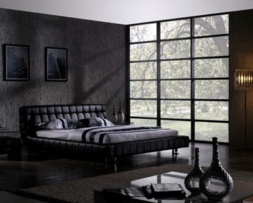 Contemporary black master bedroom with full-length windows. low platform bed and dark hardwood flooring.