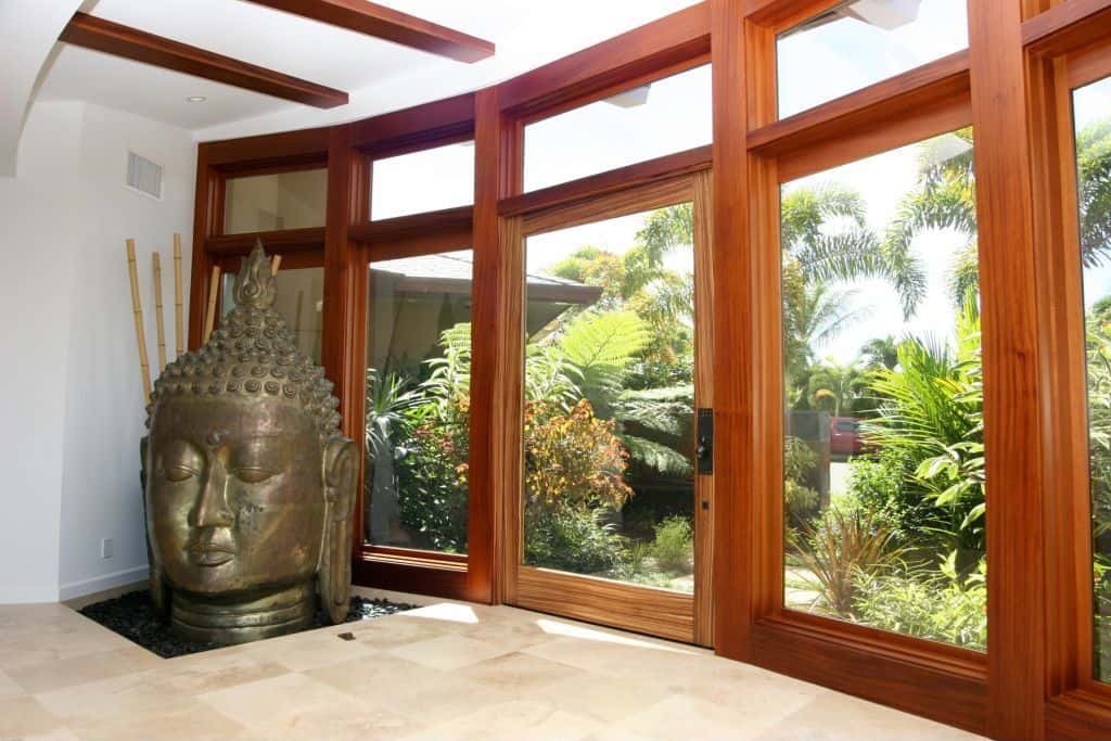 This foyer boasts glass doors and windows with thick hardwood frame.