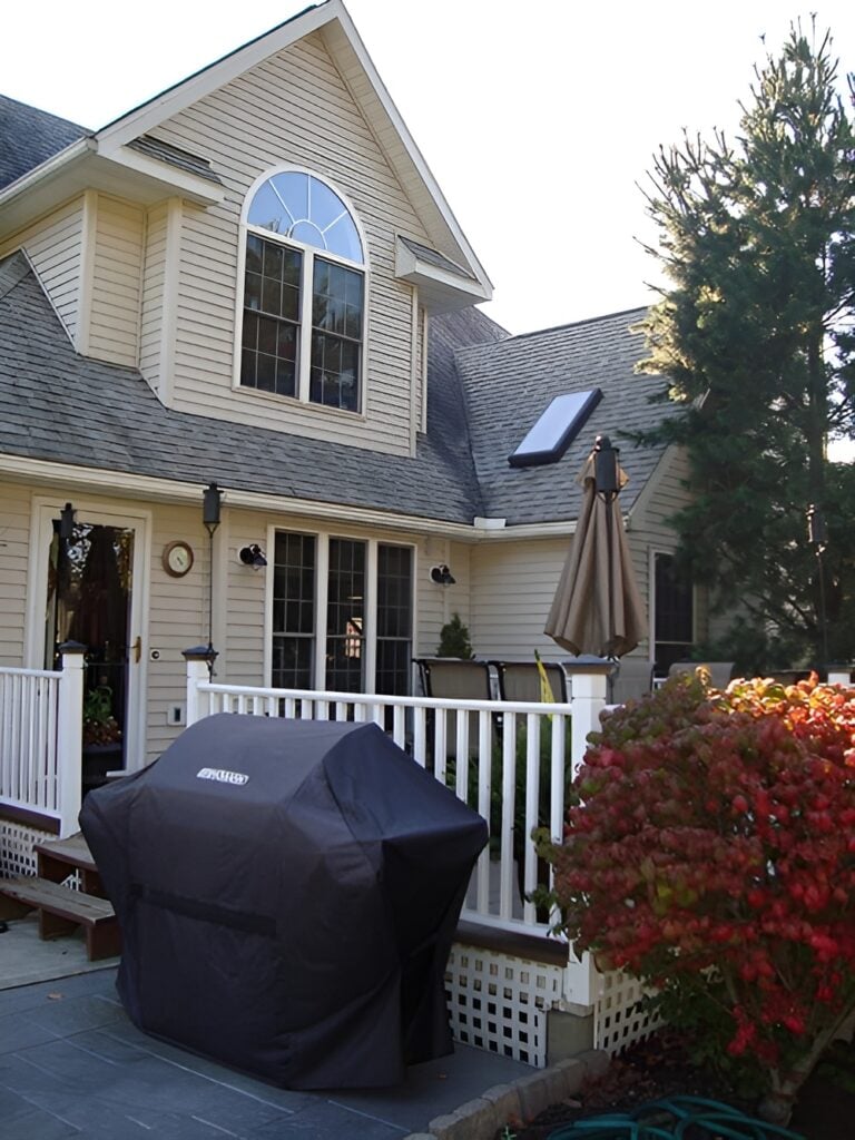 Rear exterior view showcasing its horizontal siding, large windows, and an open deck.