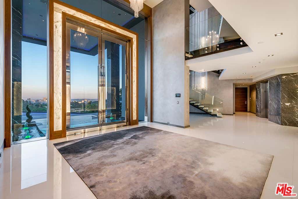 FoyerModern home featuring a large foyer. The sparkling flooring mirrors the glamorous indoor lighting.