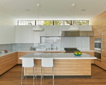 Modern kitchen a large center island featuring smooth countertops and stainless steel appliance. Photo credit: Bruce Damonte