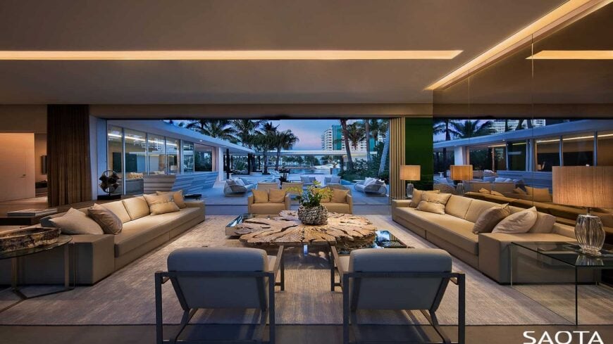 Large living room with luxurious sofa and chairs along with a glamorous center table. The lighting looks so romantic.