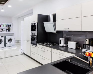 A display of home appliances in a monochrome interior.