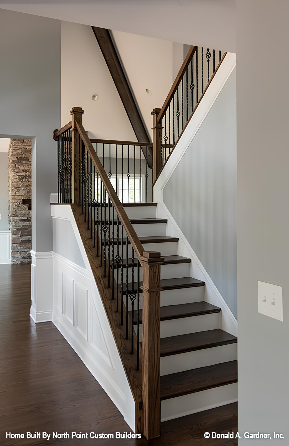 A wooden staircase off the foyer with wrought iron railings leading to the upstairs bedrooms.