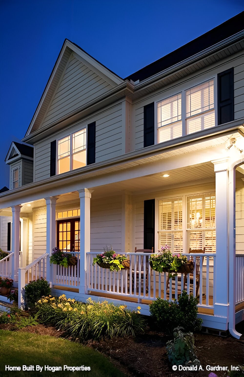Covered front porch with wooden rockers and a stoop.