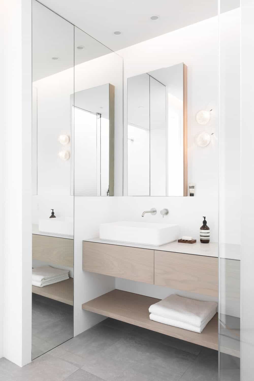 The kitchen features a vessel sink and a floor-to-ceiling mirror. Photo credit: Ema Peter