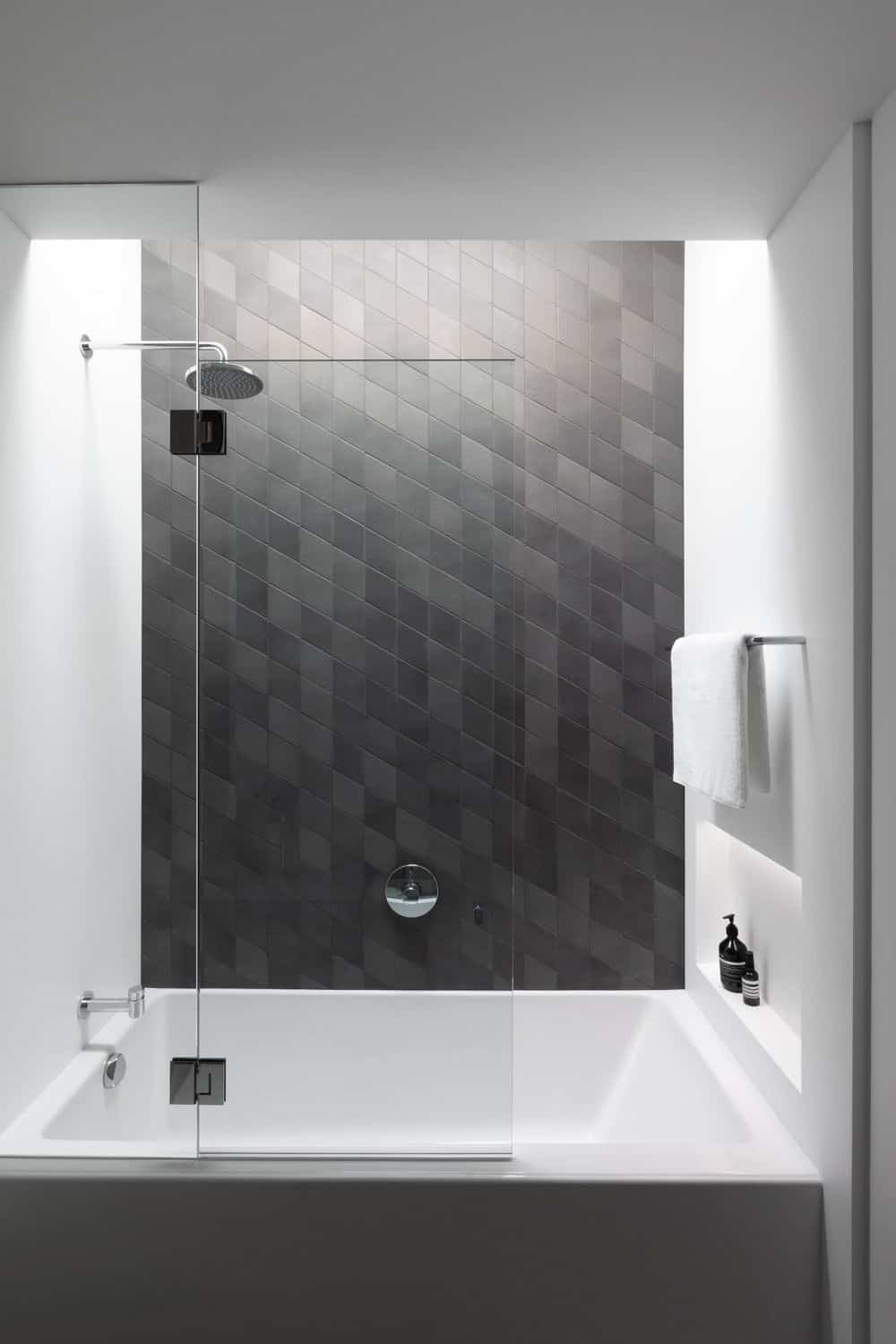 Another bathroom features a shower and tub combo with contemporary walls. Photo credit: Ema Peter