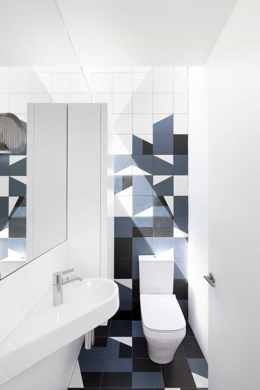 Modern style bathroom featuring a toilet and sink. Photo credit: Ema Peter
