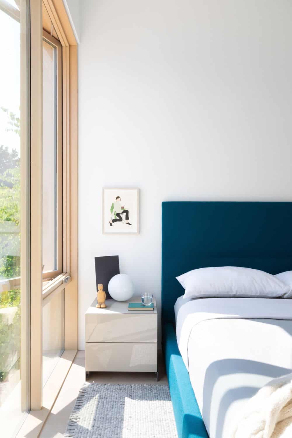 The bedroom features glass walls overlooking the beautiful outdoor. Photo credit: Ema Peter