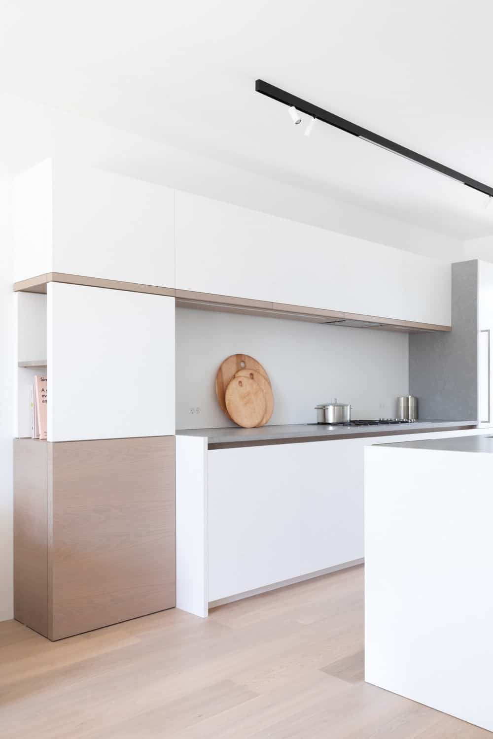 Another view of the kitchen featuring its white walls, smooth counters and white walls. Photo credit: Ema Peter
