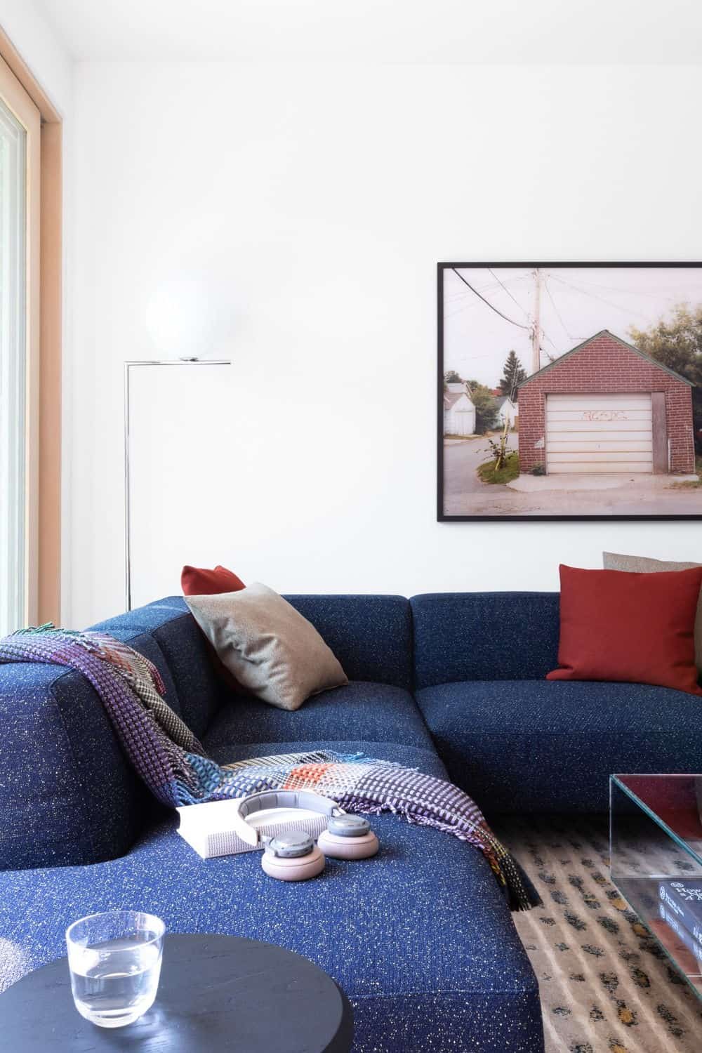 Close up shot at the living room's blue couch with a beautiful carpet, center table and wall decor. Photo credit: Ema Peter