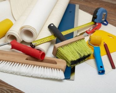 A set of tools that are being used to apply wallpaper.