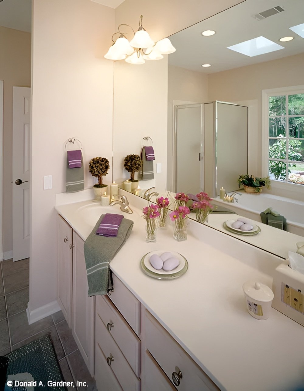 Primary bathroom with a dual sink vanity, a walk-in shower, and a drop-in bathtub reflected in the frameless mirror.