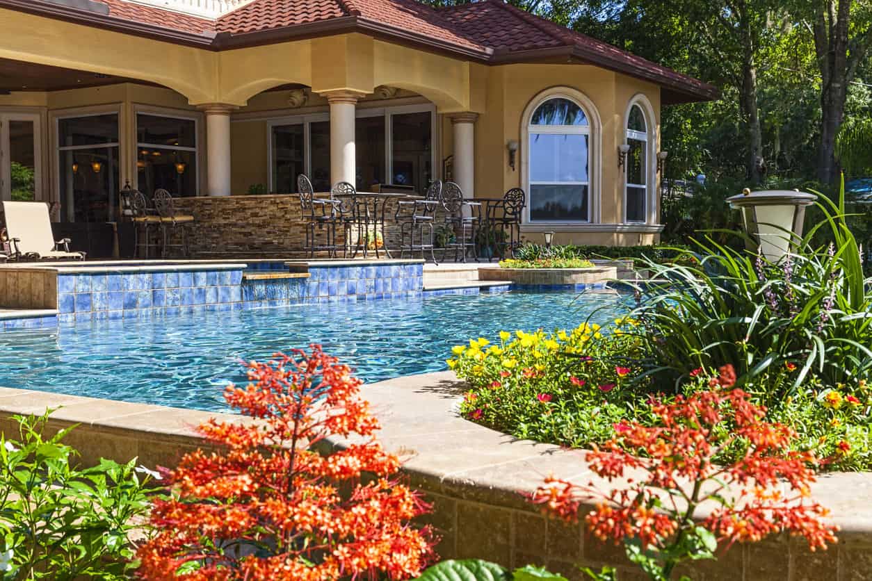 Mediterranean style home with a Mediterranean style pool. Check out the blue tile made to look like a cascading waterfall into this beautiful rectangle pool surrounded by colorful gardens.