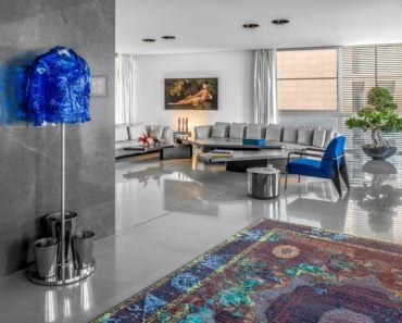 Super cool contemporary condo living room with large grey sofas and bright blue accent chair