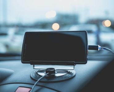 Mobile phone charging plugged on car console.