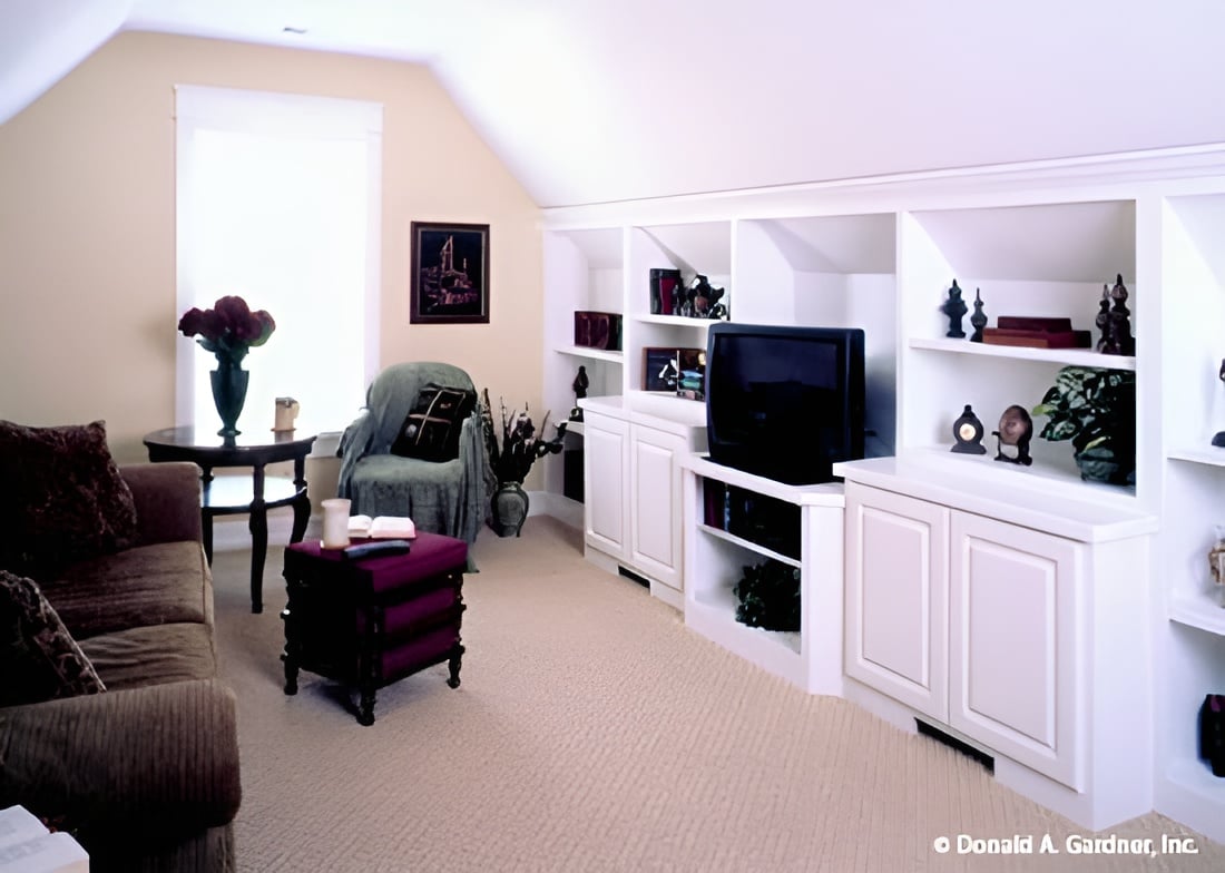 Bonus room with a coved ceiling, white built-ins, and comfy seats.