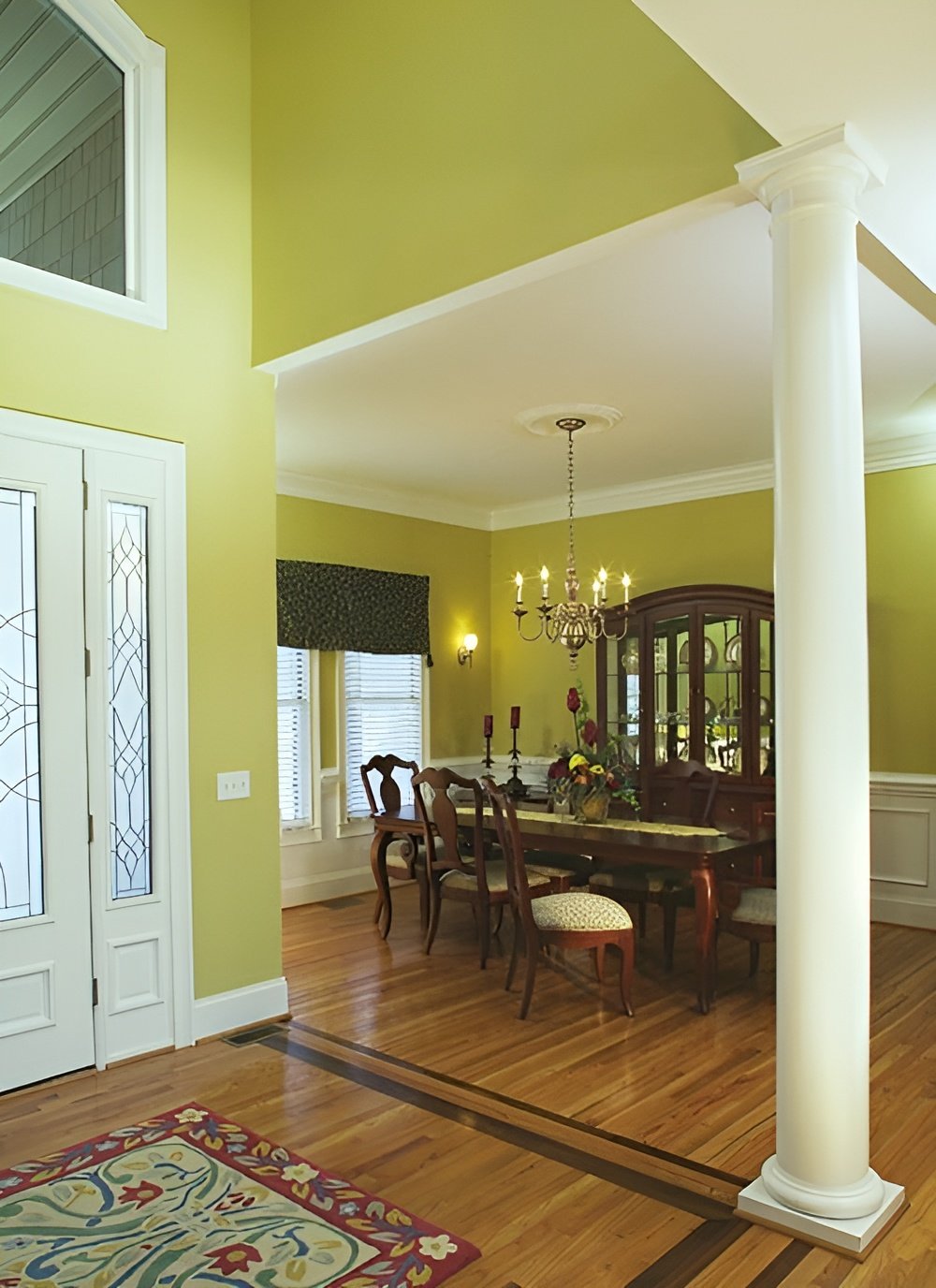 Formal dining room with a china cabinet and a matching dining set well-lit by a candle chandelier.