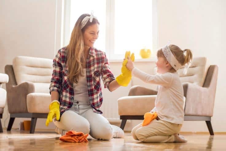 Mother and child smiling as they are cleaning and having fun