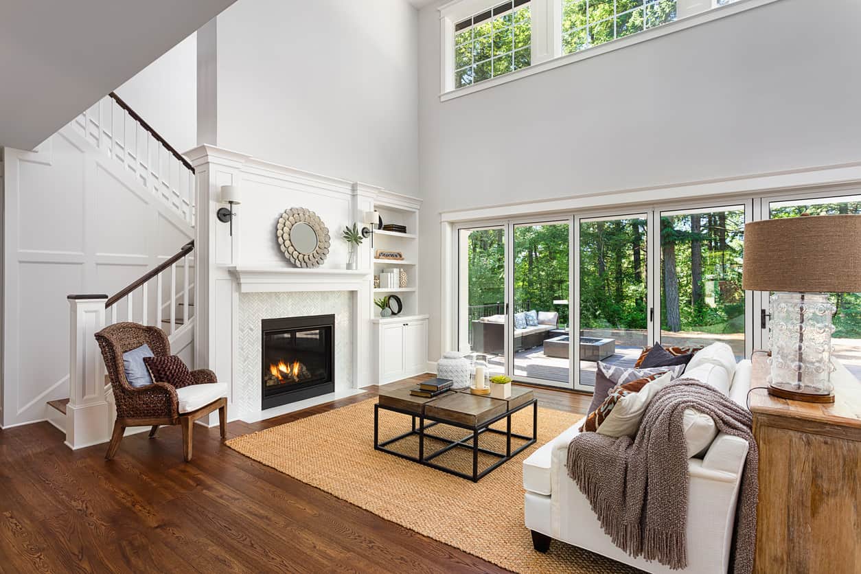 This living room is small but the cool toned light hardwood floors and matching furniture make it look spacious. The singular pop of color comes from the blue armchair.