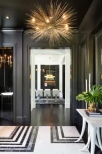 Luxe tiled flooring and bold black walls adorn this gorgeous foyer. Tons of moulding throughout the walls creates depth and interest in the space.