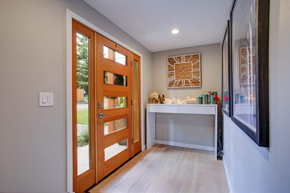 Small modish foyer featuring gray walls with stylish decors. The hardwood flooring matches the gray walls perfectly.