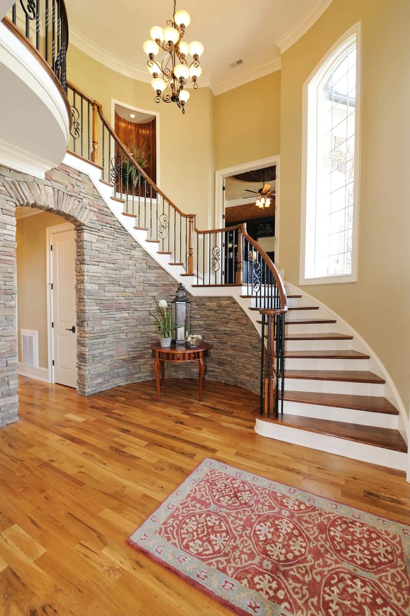 This large foyer boasts a beautiful hardwood flooring and rug combination. The brick walls perfectly fits with the foyer's design.