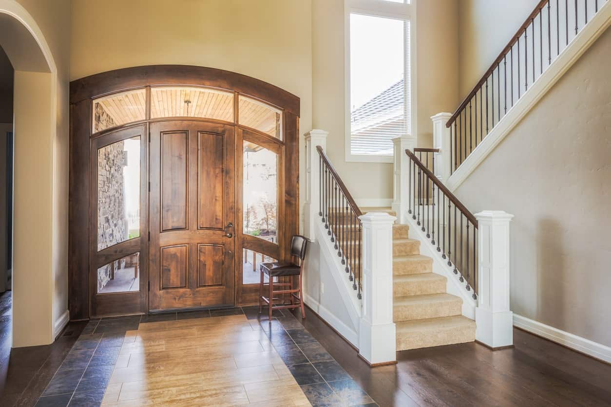 This simple yet classy large foyer features a stylish combination of hardwood and tiles flooring. The walls fits perfectly with the foyer's door style.